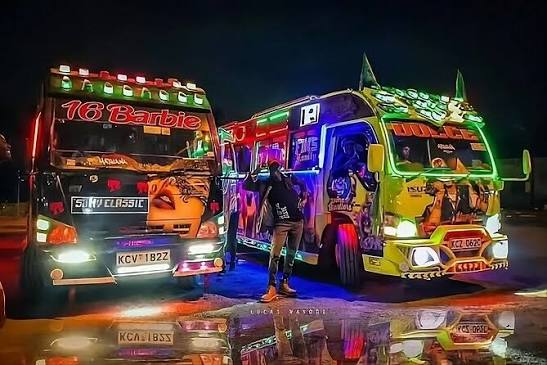 Two neon-lit Nairobi matatus parked at night as passengers step out