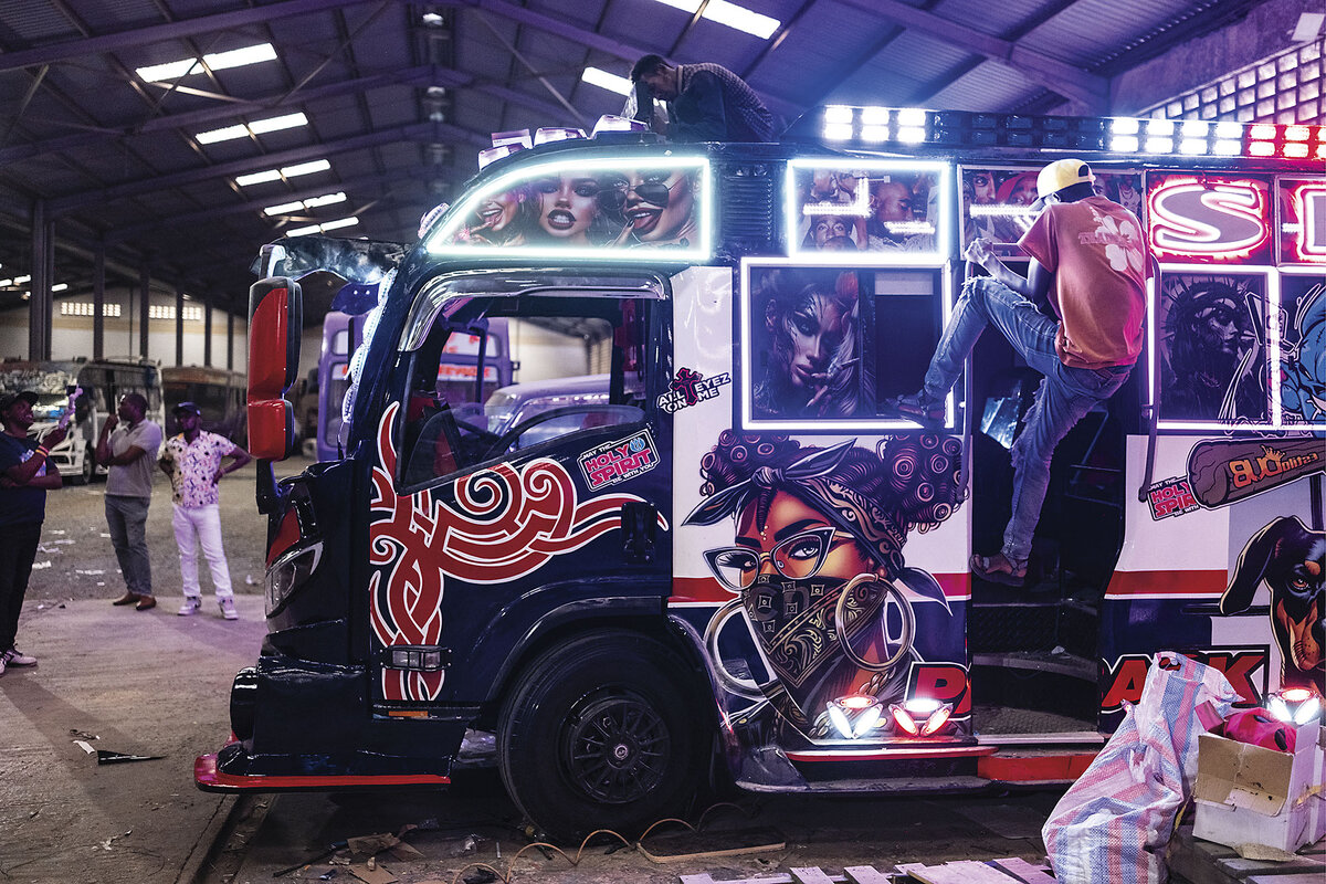 A graffiti-covered Nairobi matatu being detailed inside a garage